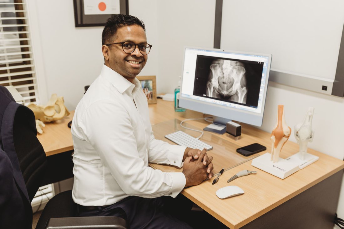 Dr Ravi Dissanayake at his desk in his consulting room